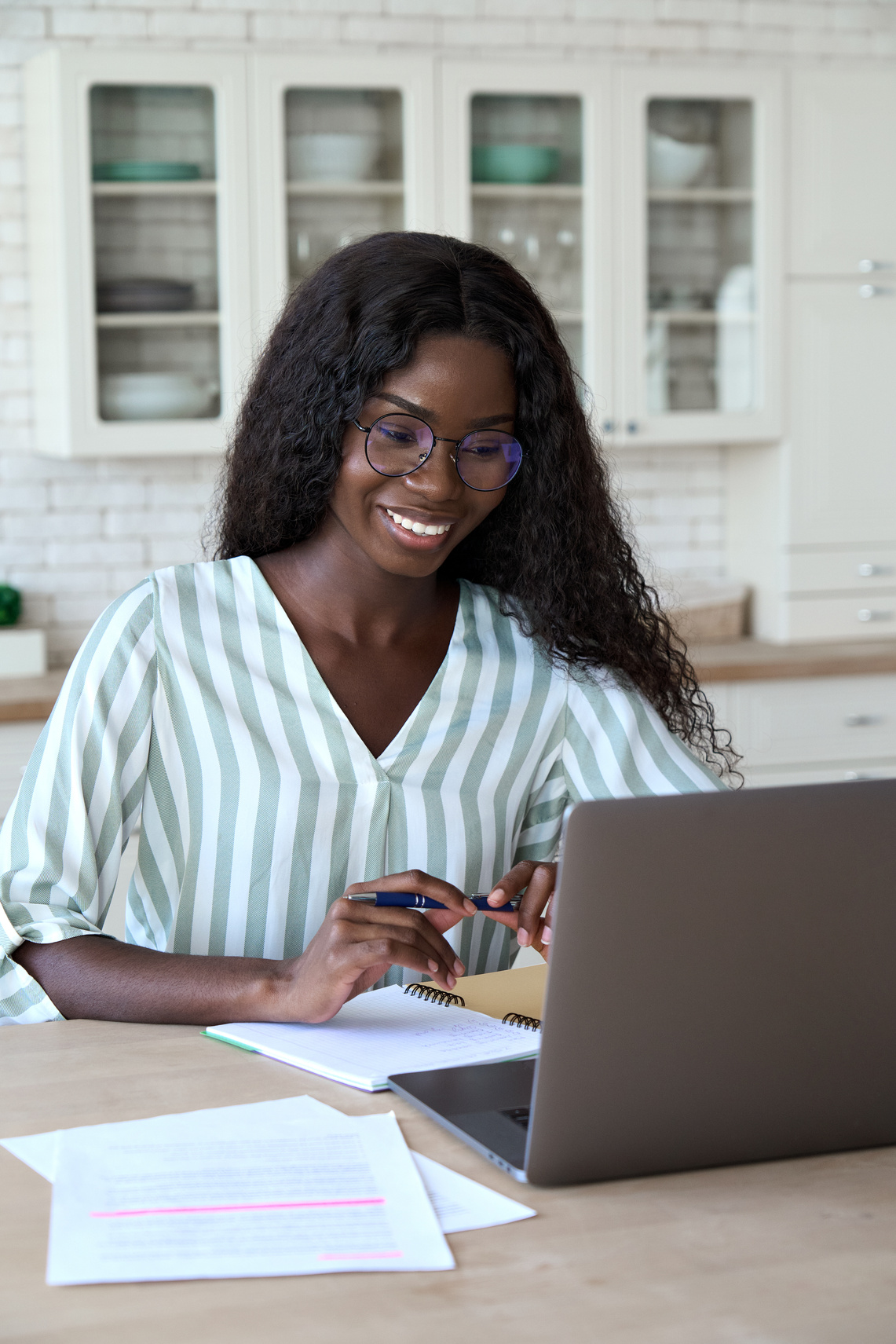 Smiling Woman Scrolling Through a Laptop 